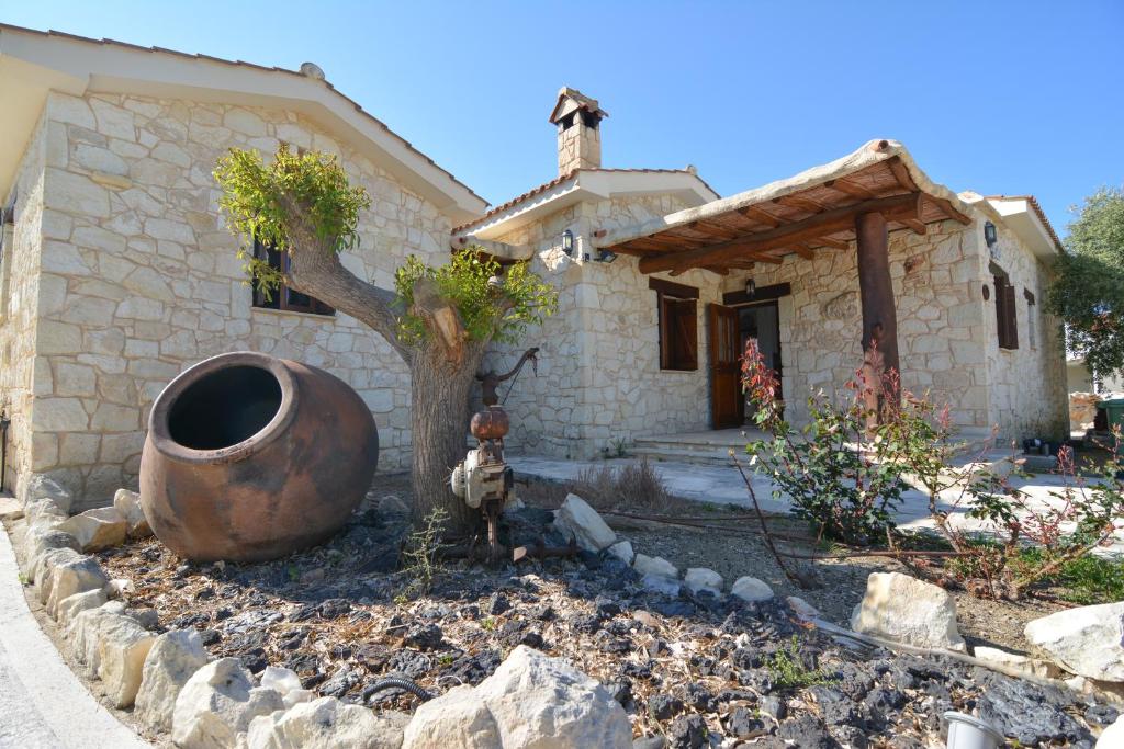 een huis met een grote vaas ervoor bij La Estancia in Polis Chrysochous