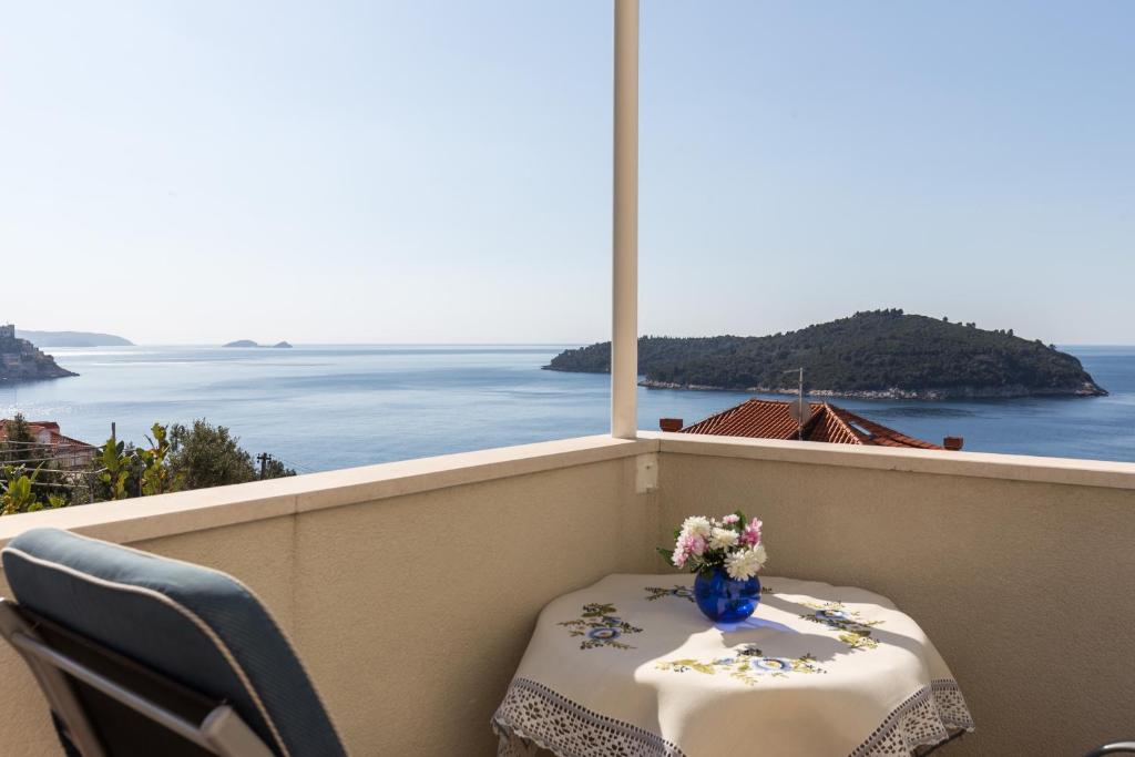 una mesa con un jarrón de flores en el balcón en Apartment Rose Garden, en Dubrovnik