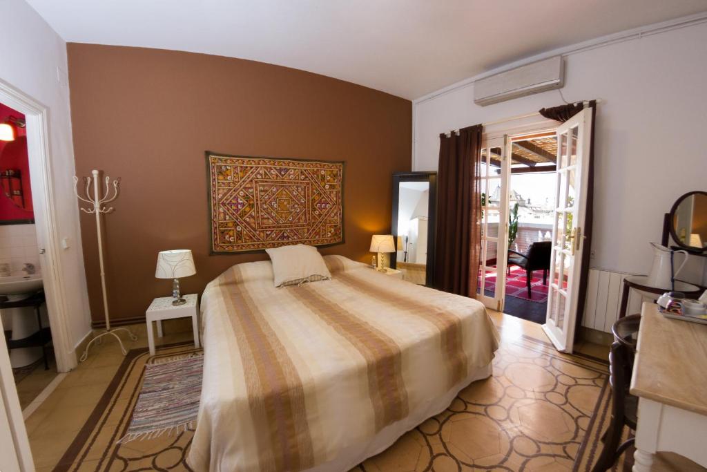 a bedroom with a bed and a painting on the wall at Villa Alicia Guest House in Málaga
