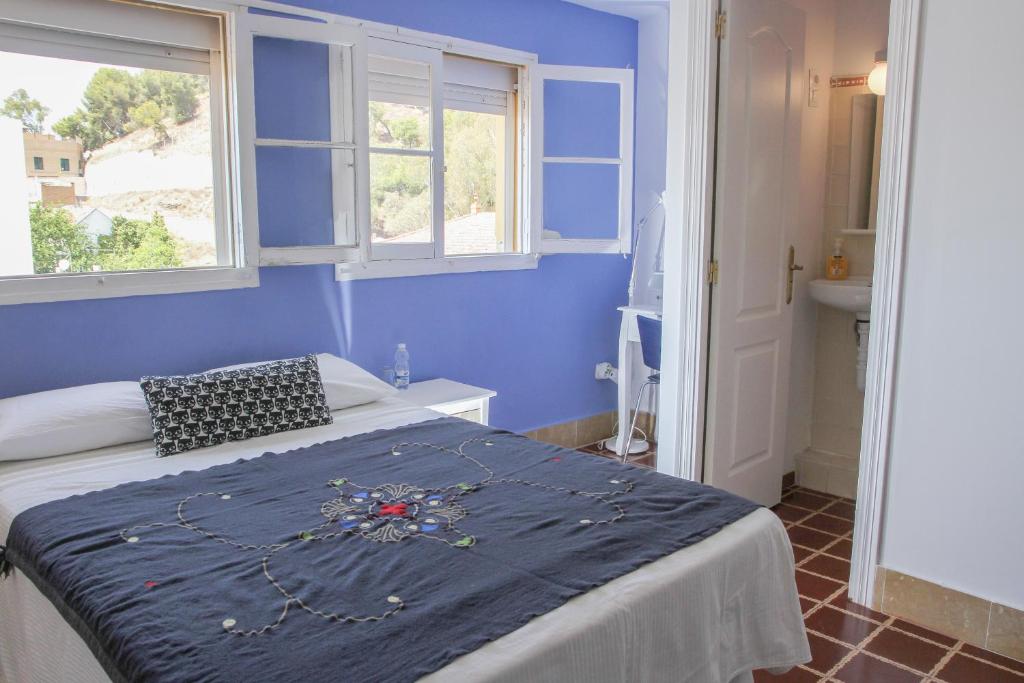
a bedroom with a bed and a window at Villa Alicia Guest House in Málaga
