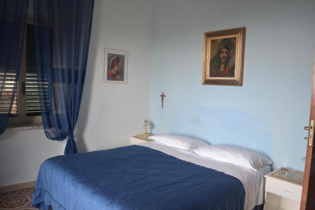 1 dormitorio con cama con sábanas azules y ventana en B&B Ilys, en Cava deʼ Tirreni