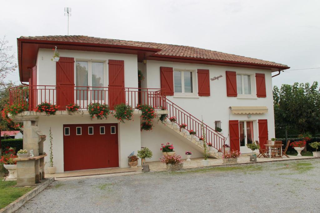 una casa con persianas rojas y garaje en Maithagarria, en Aicirits