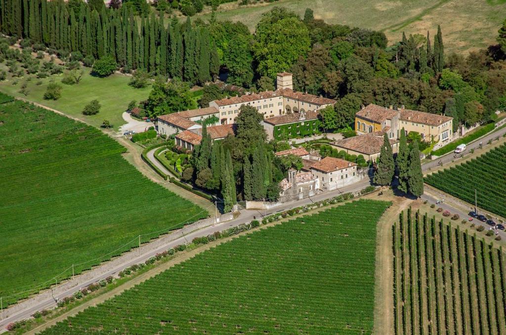 une vue aérienne sur une grande maison dans un champ dans l'établissement La Foresteria Serego Alighieri, à SantʼAmbrogio di Valpolicella