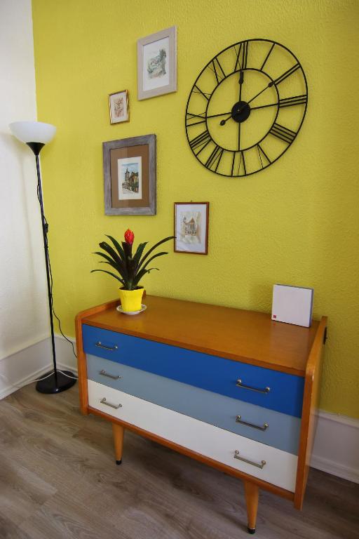 une horloge sur le mur au-dessus d'une commode dans une pièce dans l'établissement Le Jules, à Colmar