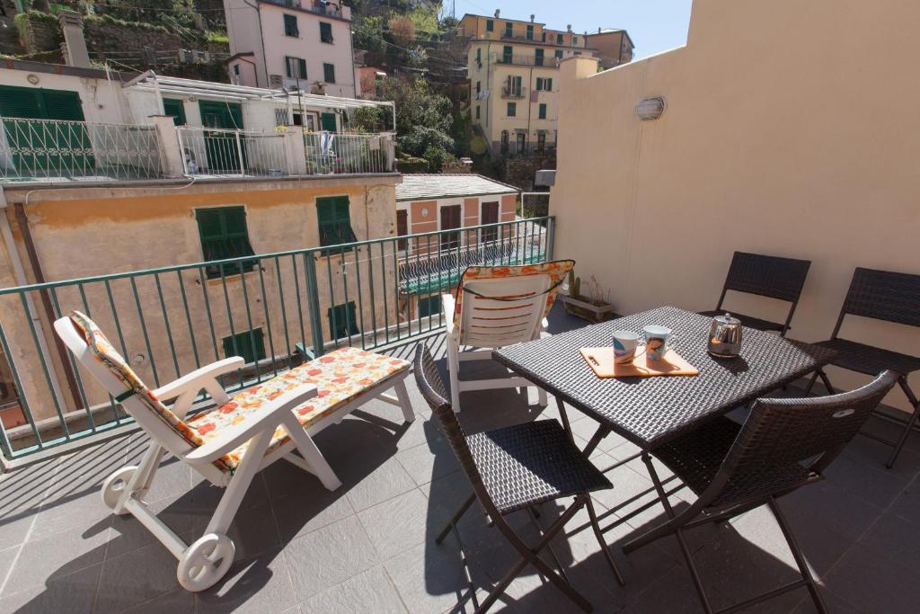 eine Terrasse mit einem Tisch und Stühlen auf dem Balkon in der Unterkunft L'Ancora in Riomaggiore