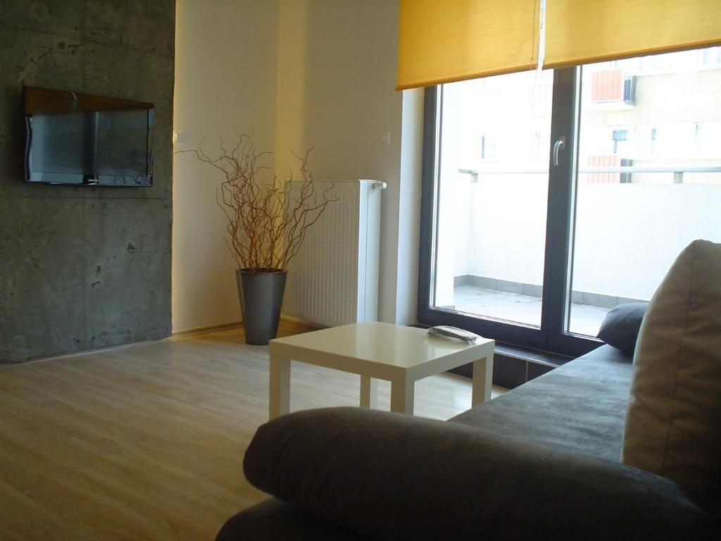 a living room with a couch and a table at Pirelli Apartament in Warsaw