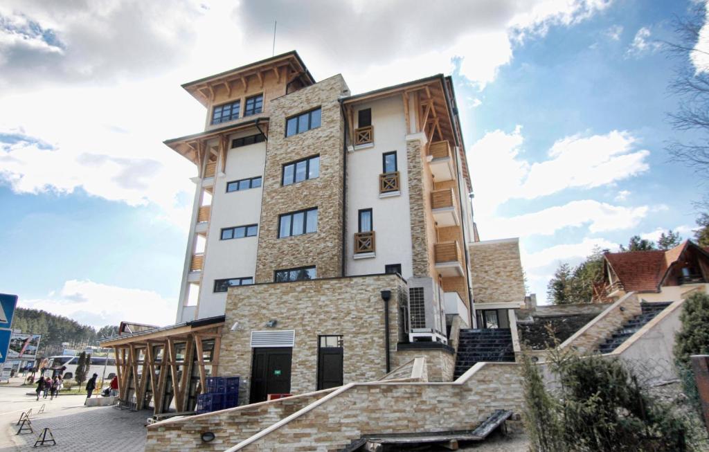 a tall building with stairs in front of it at Šišarka Apartmani Zlatibor in Zlatibor