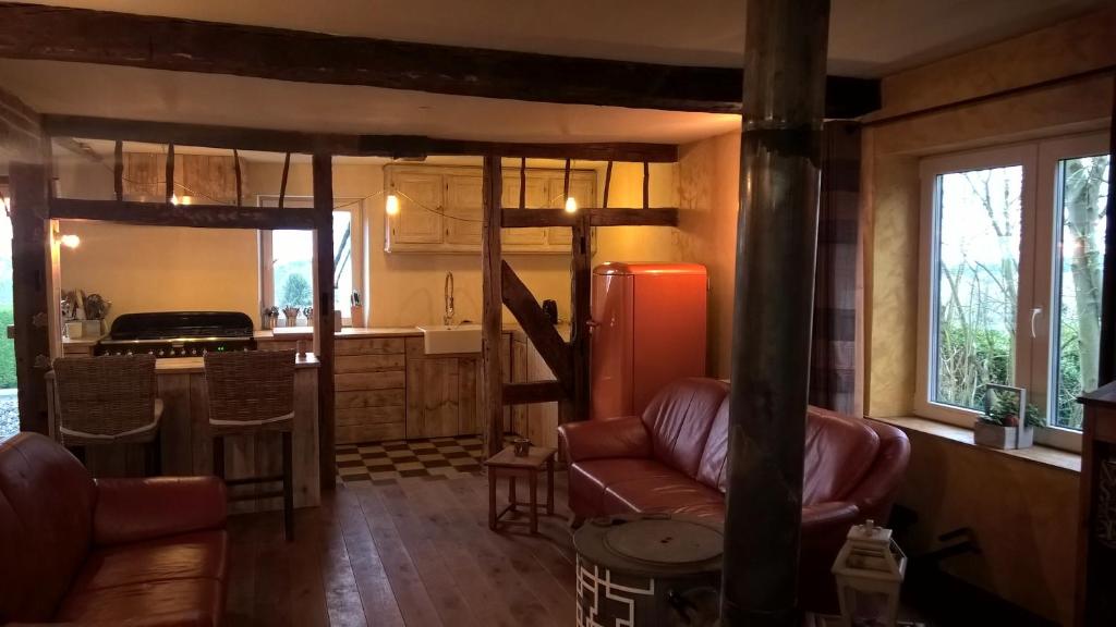 a living room with a couch and a kitchen at Vakantiehuis Le Colombage in Beauraing