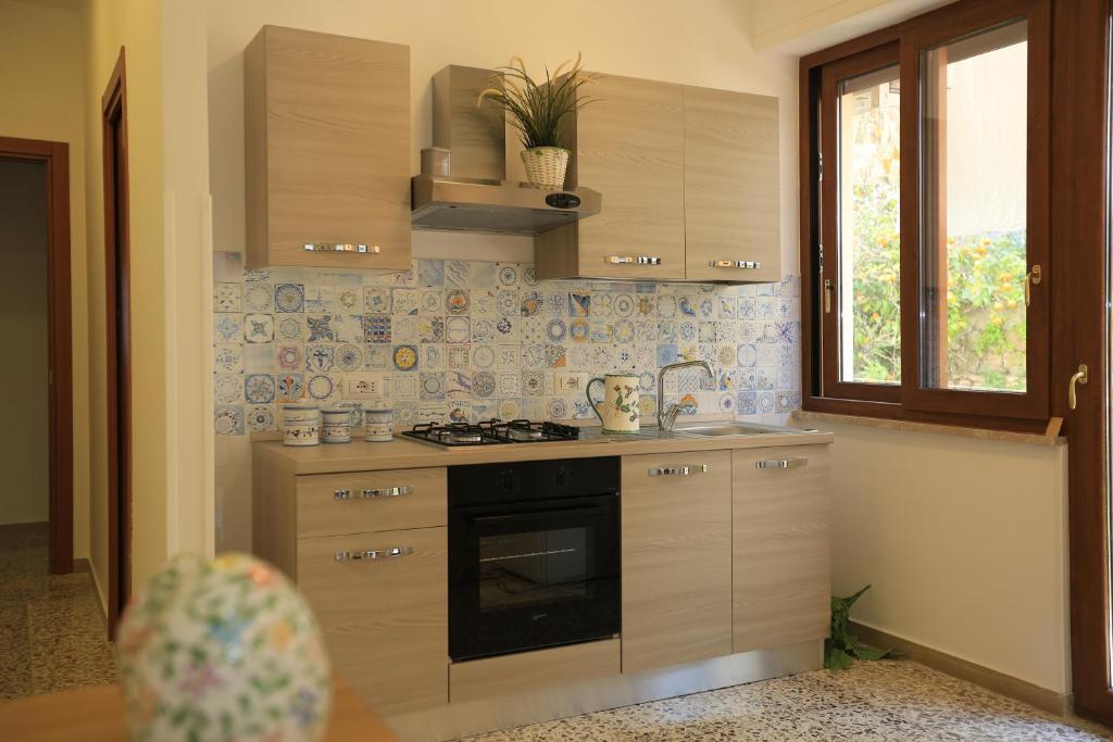 a kitchen with a stove and a sink and a window at Casa Il Coccio in Sorrento