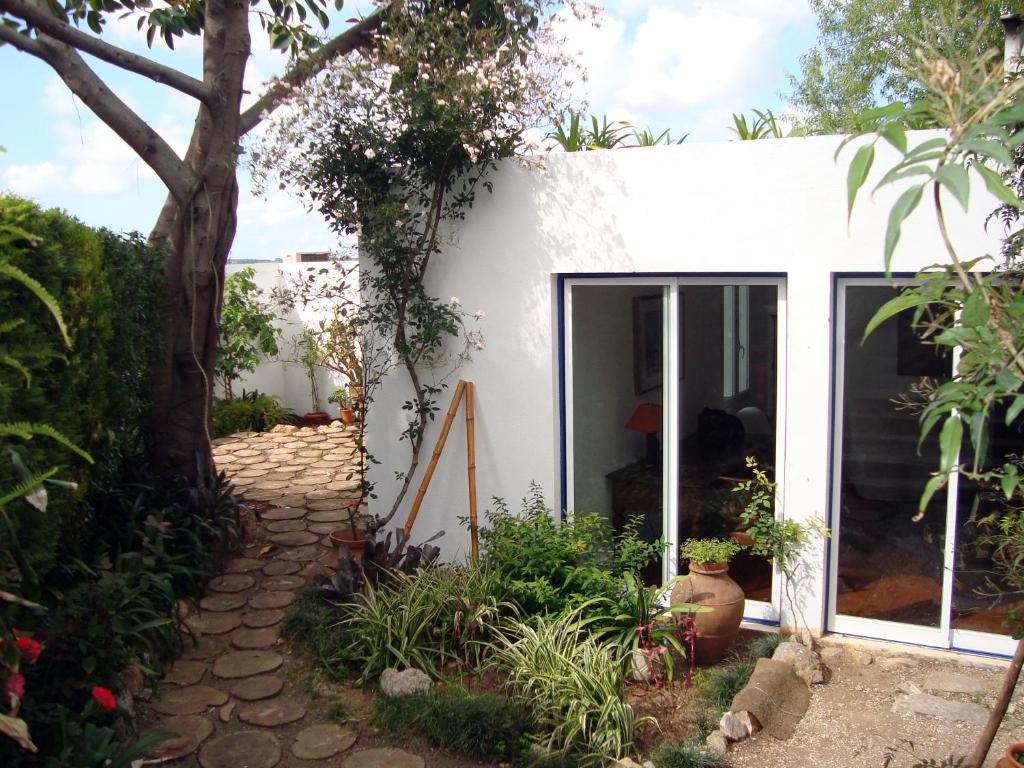 una casa blanca con un árbol en el patio en Casa do Jasmim, en Sintra