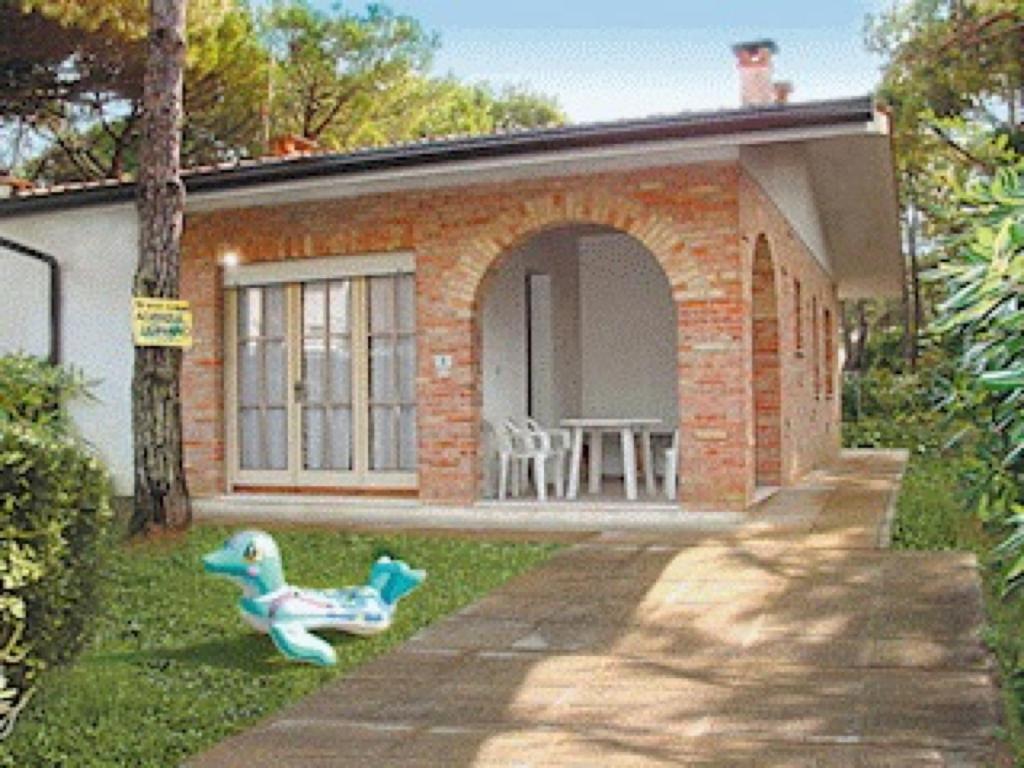 リニャーノ・サッビアドーロにあるVilla a Lignano Riviera con giardinoの小さなレンガ造りの家(テーブルと椅子付)