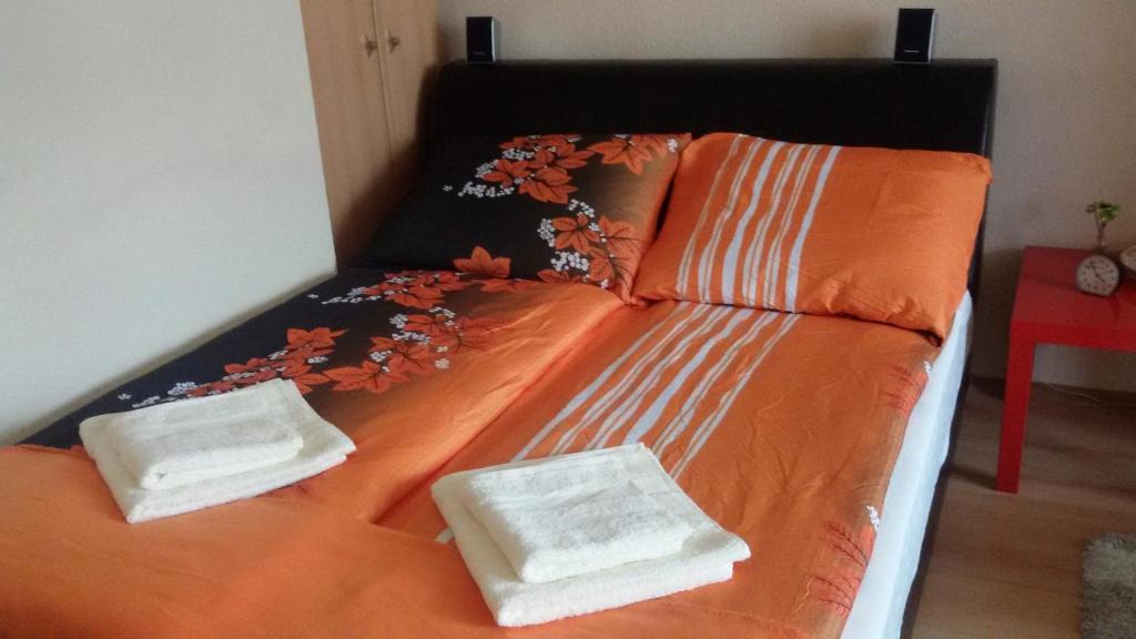 A bed or beds in a room at Liget Apartman