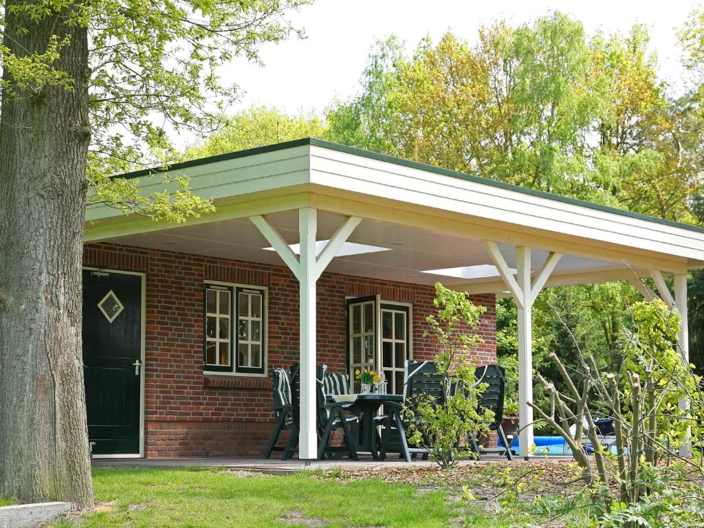 awning over a brick house with a patio at Cozy Holiday Home in Reutum with Jacuzzi in Weerselo