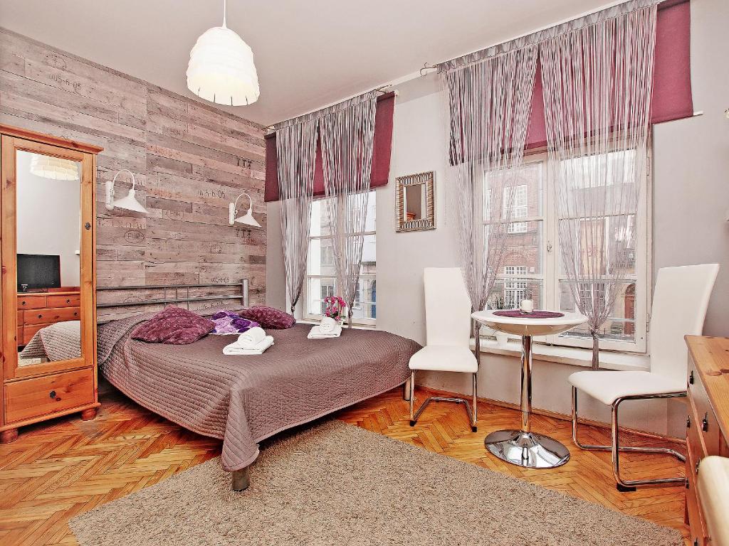 - une chambre avec un lit, une table et des chaises dans l'établissement Apartament Kameralny na Starówce, à Gdańsk