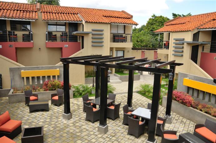 a patio with benches and tables in a courtyard at Wayak Hotel in Managua