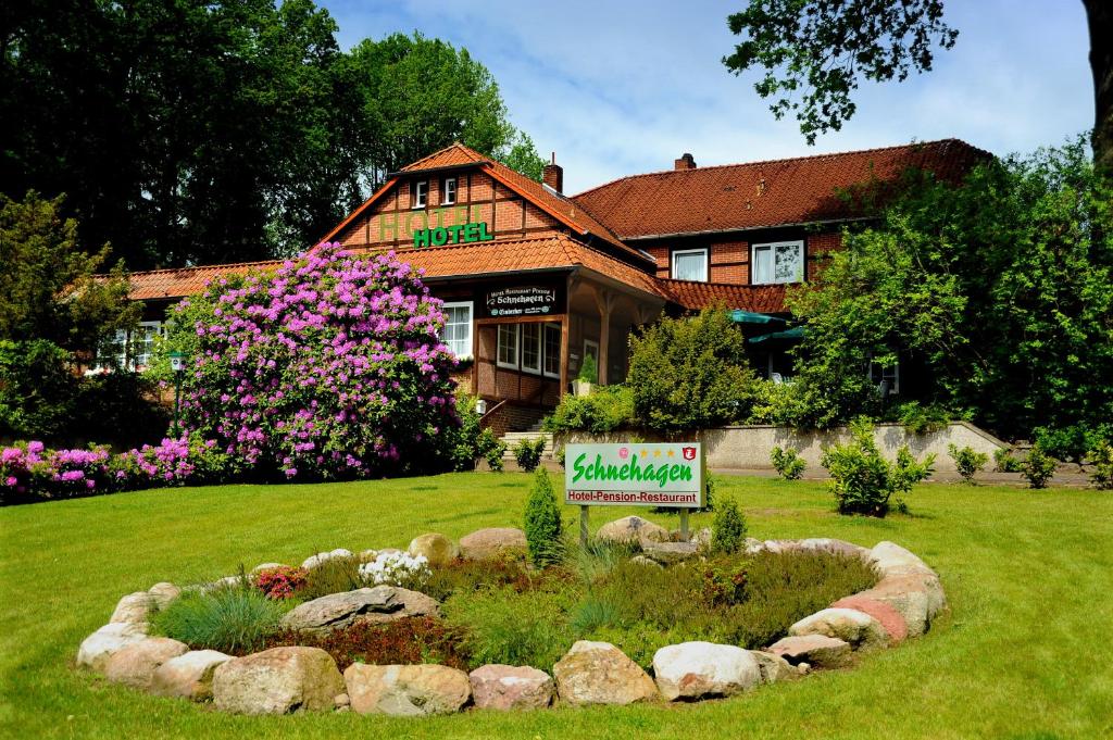 ein Haus mit einem Schild vor einem Hof in der Unterkunft Hotel Schnehagen in Bad Fallingbostel