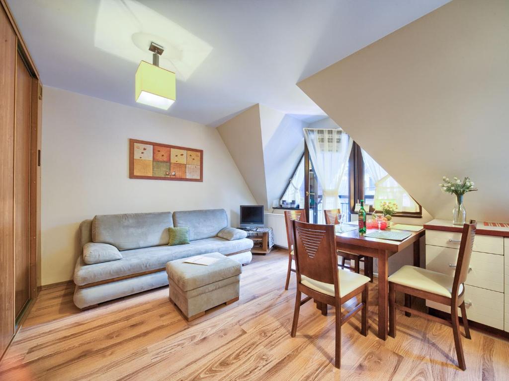 sala de estar con mesa y sofá en VisitZakopane - Olymp Apartament, en Zakopane