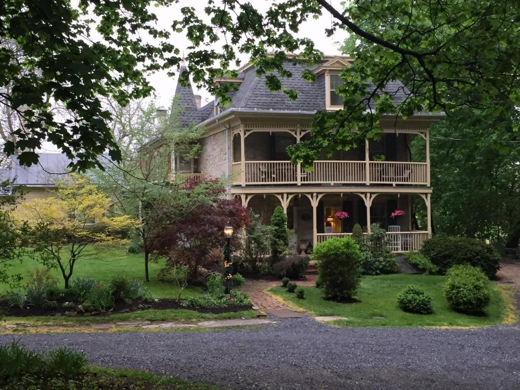 a large house with a porch and a yard at Fallen Tree Farm Bed and Breakfast in Carlisle