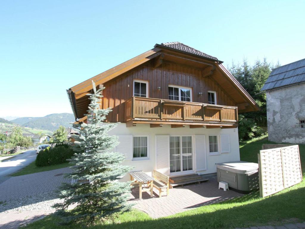 una piccola casa con balcone e albero di Chalet in Lungau with sauna and hot tub a Sankt Margarethen im Lungau