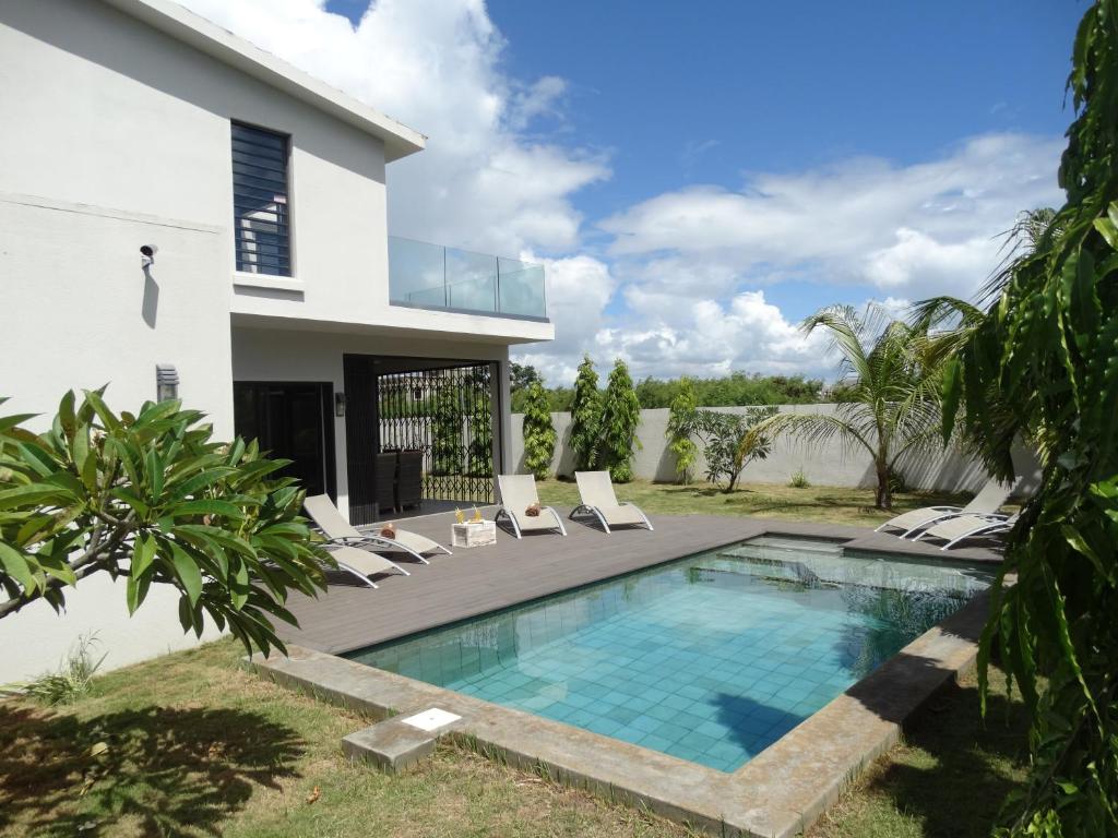 a villa with a swimming pool and a house at Villa Soleil in Trou aux Biches