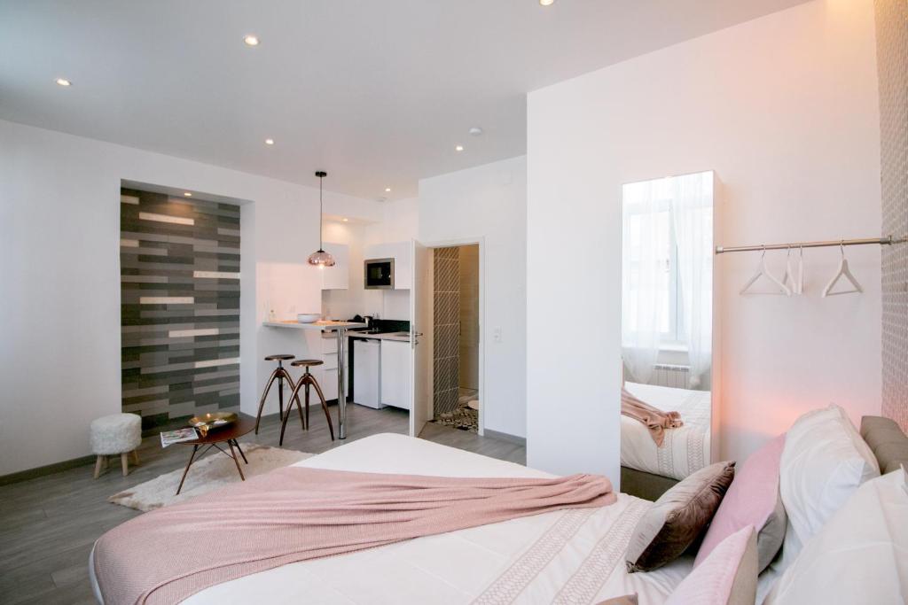 a bedroom with a large bed and a kitchen at MIDPOINT STUDİOS by Life Renaissance in Strasbourg