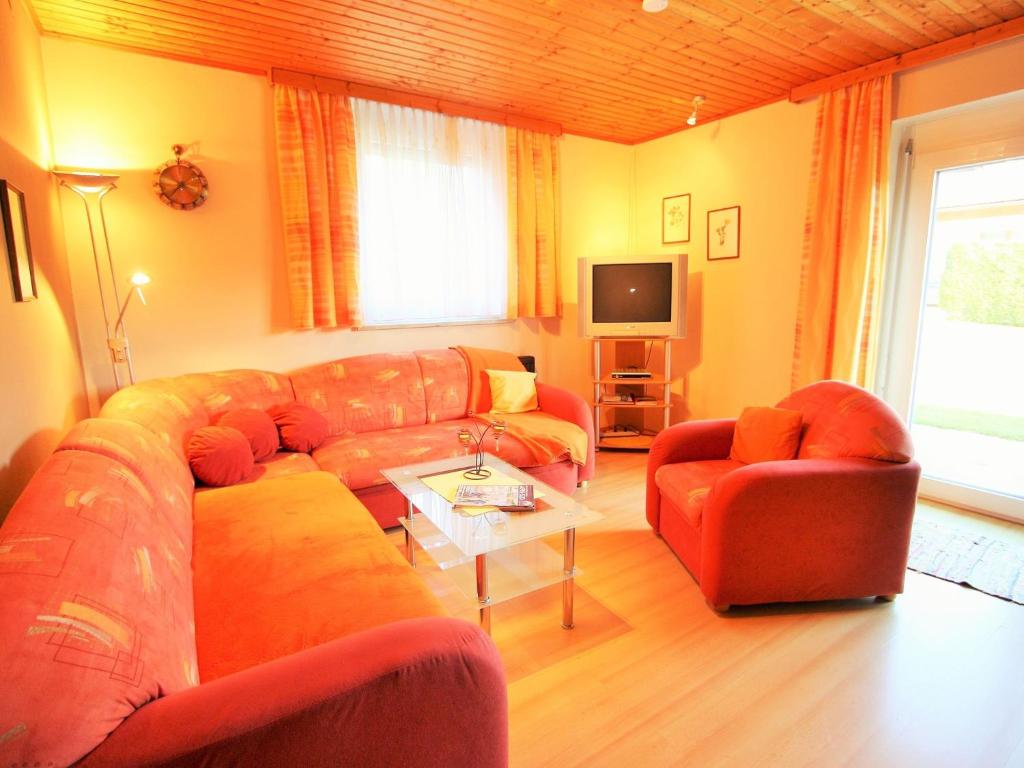 a living room with a couch and two chairs and a tv at Apartment in Feldkirchen near Ossiacher See in Feldkirchen in Kärnten