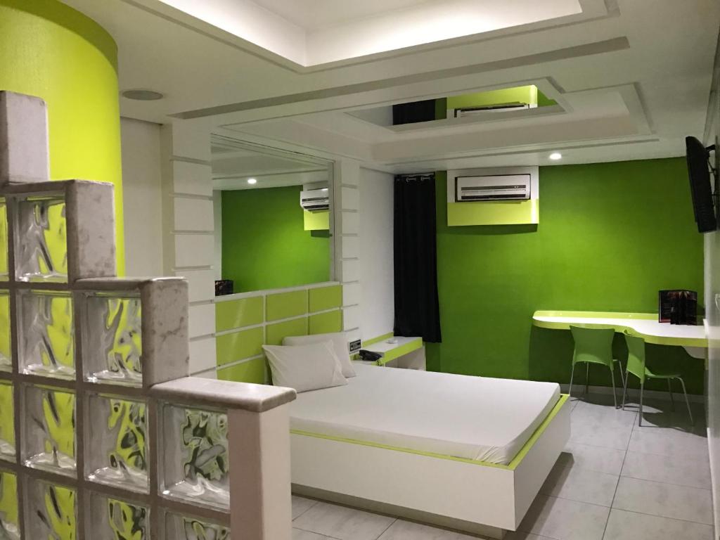 a hospital room with a bed and a green wall at Luna Motel in São Bernardo do Campo