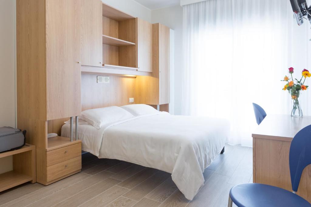 a bedroom with a white bed and a window at Hotel Mediterraneo in Sottomarina