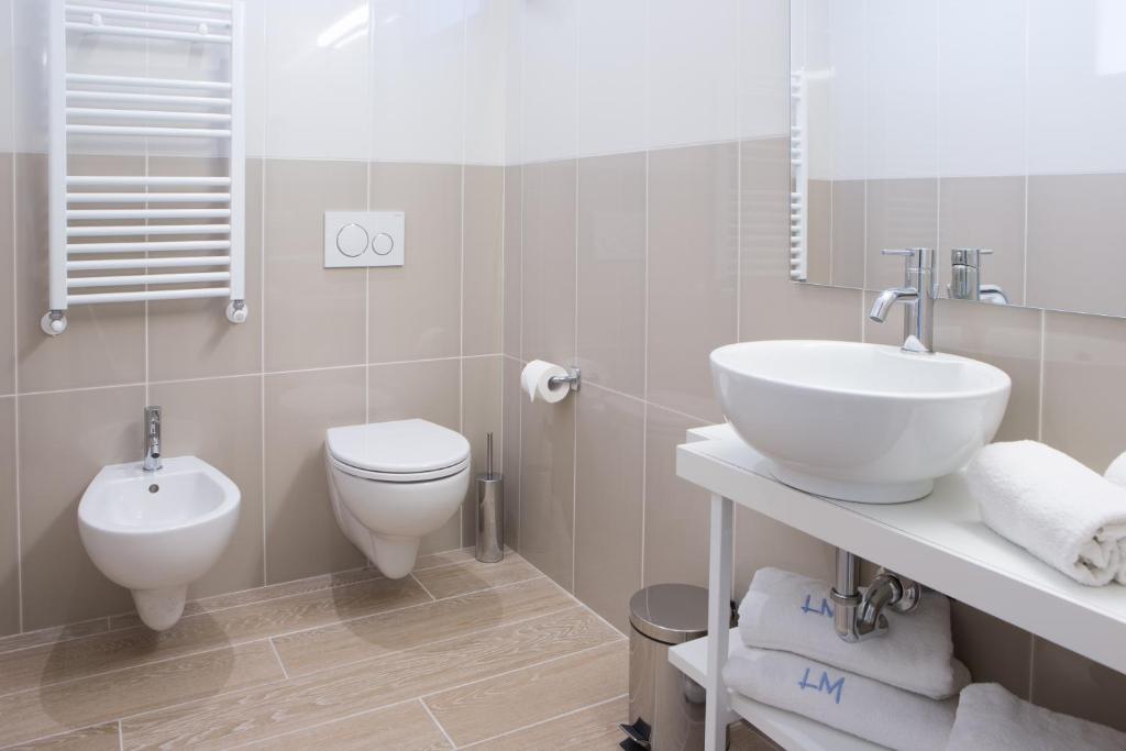 a white bathroom with a sink and a toilet at Hotel Mediterraneo in Sottomarina