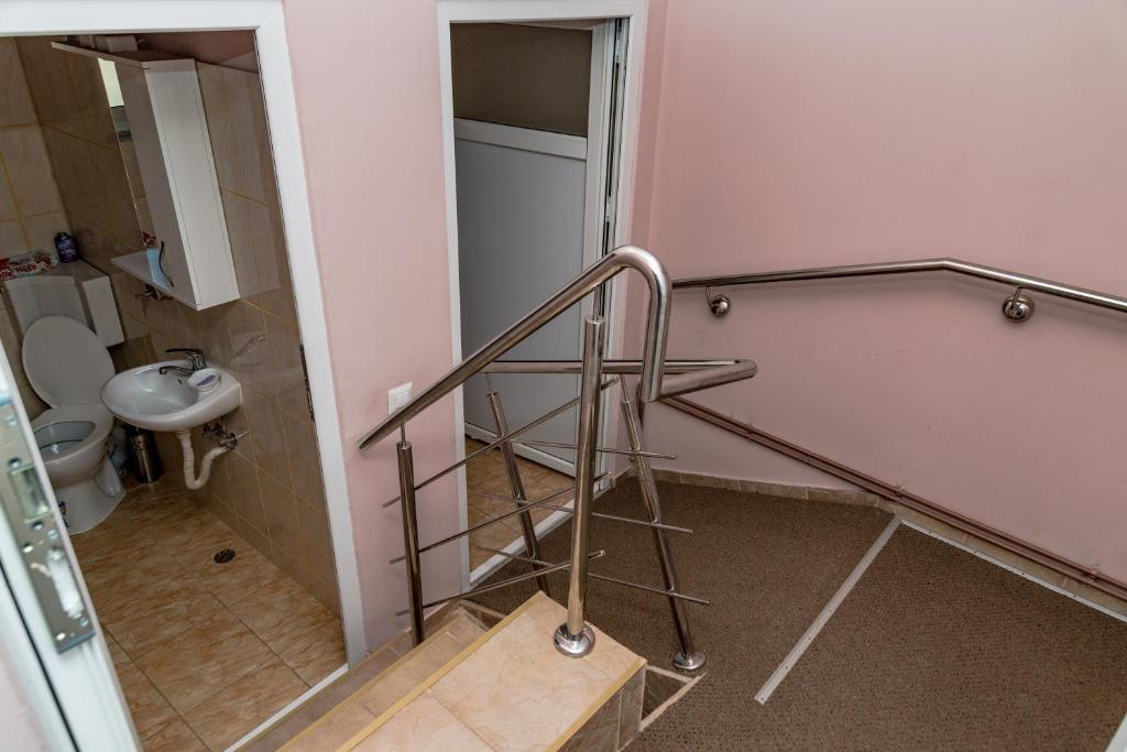 un baño con una escalera que conduce a un aseo en Noring Guest House en Lupeni