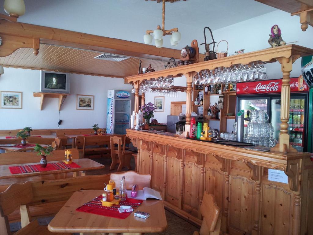 eine Bar in einem Restaurant mit einem Tisch und Stühlen in der Unterkunft Zlatnoto Pile Restaurant & Rooms in Kranewo