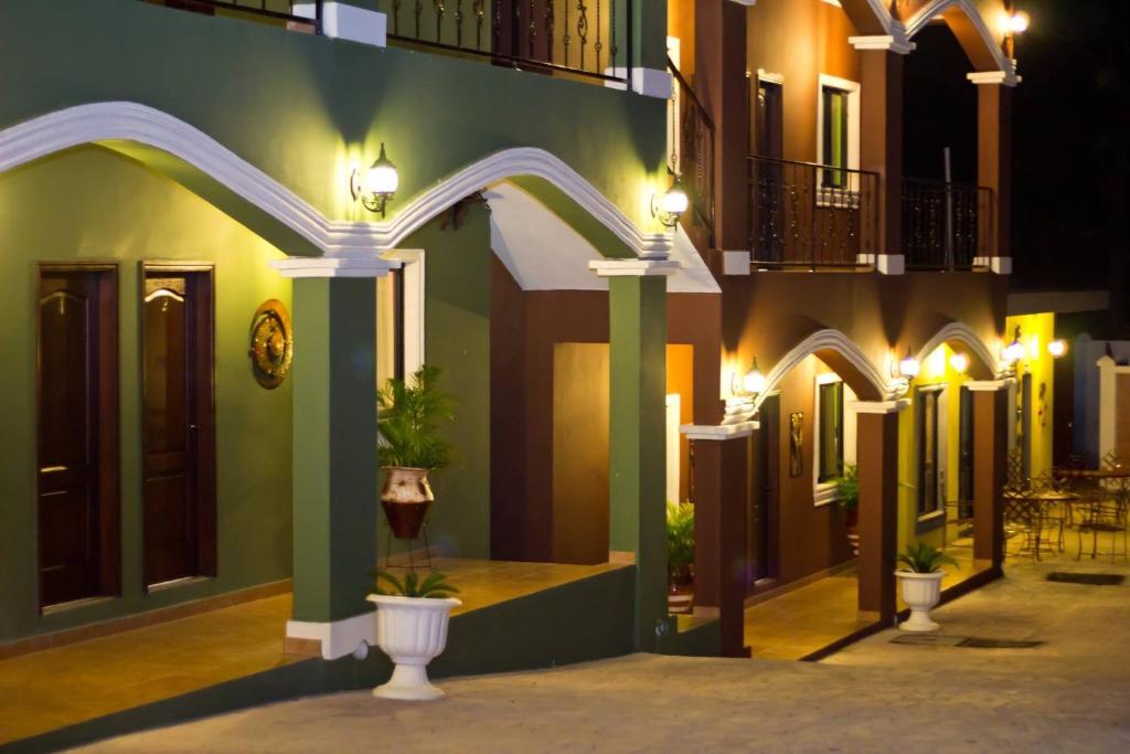 un edificio con columnas y luces en una calle en Hotel Boutique Casa D' Luna, en Choluteca