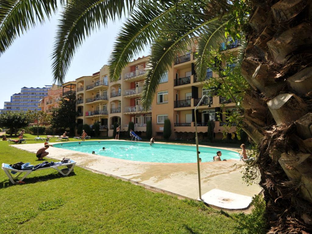 a swimming pool in front of a building at Belvilla by OYO Comte de Empuries Apt C in Empuriabrava