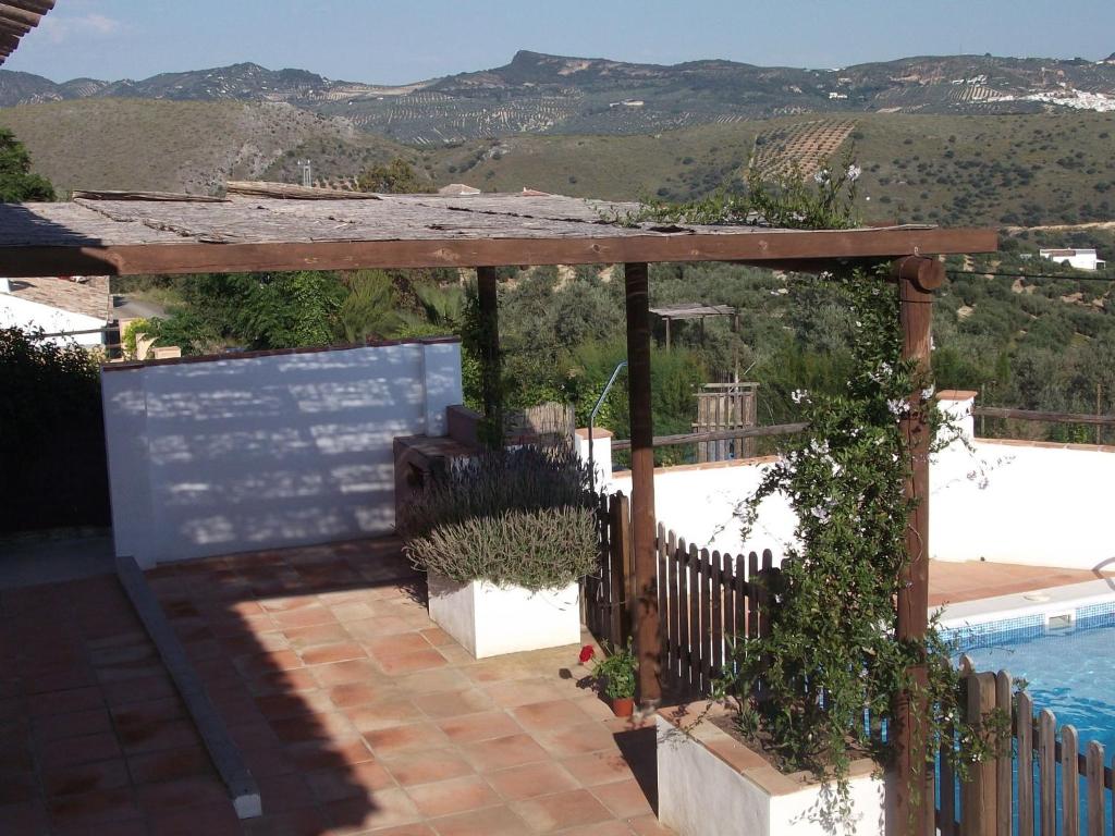 Fuentes de CesnaにあるSpanish Farmhouse in Andalusia with Private Swimming Poolのスイミングプール横の木製パーゴラ