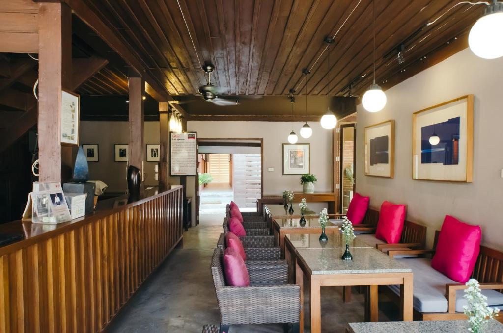 um restaurante com almofadas cor-de-rosa, mesas e cadeiras em Lilu Pai em Pai