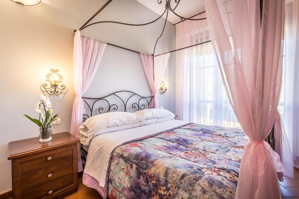 um quarto com uma cama de dossel e cortinas cor-de-rosa em B&B Antiche Armonie em Florença