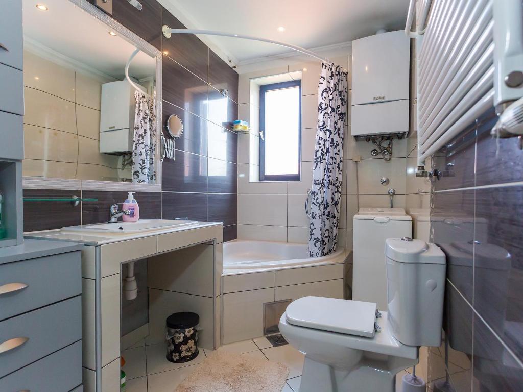 a bathroom with a toilet and a sink and a tub at Apartments Špadići in Poreč