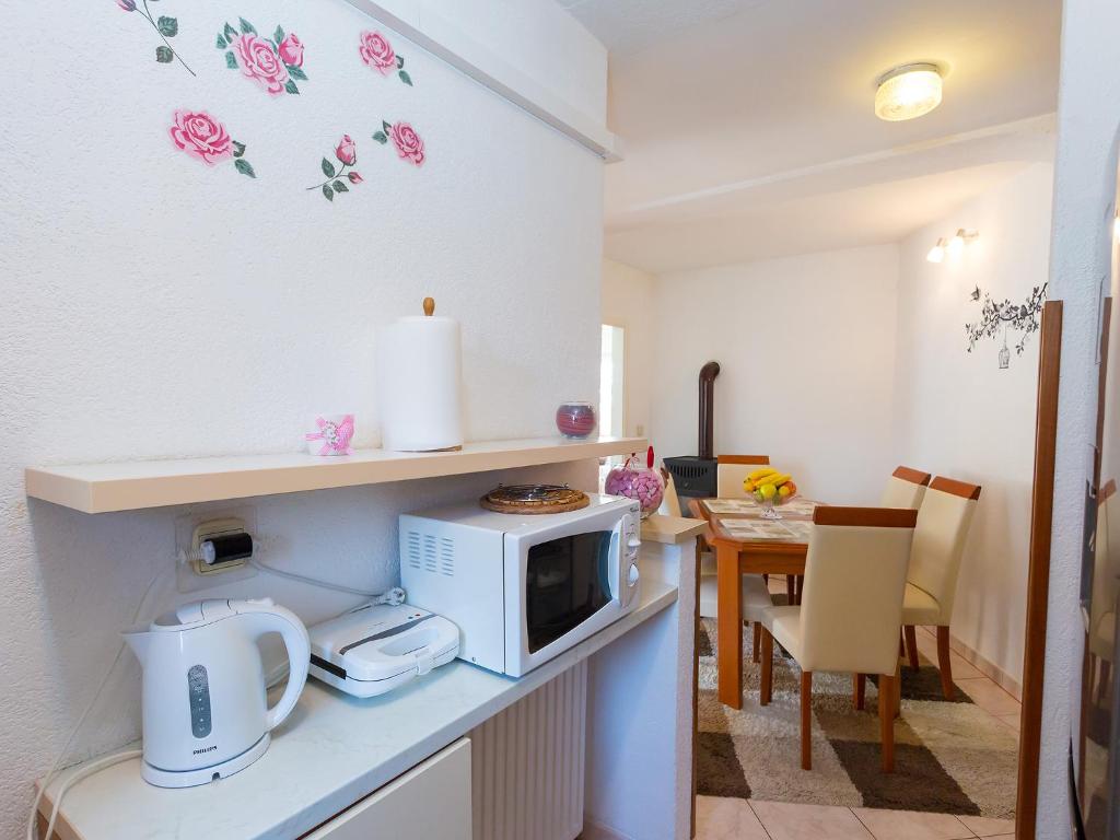 a kitchen with a microwave on a counter with a table at Apartments Špadići in Poreč