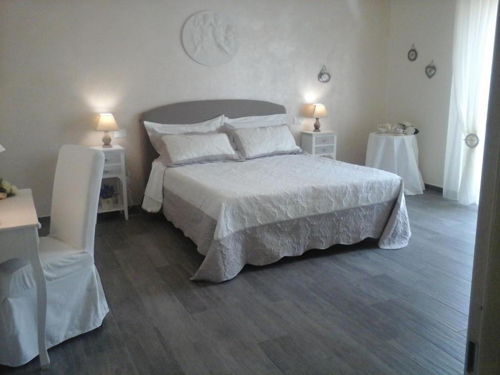a bedroom with a large white bed and two tables at Carpe Diem in La Spezia