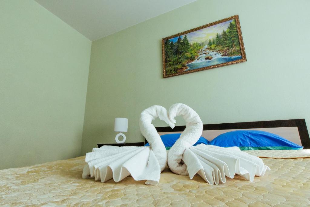 una cama con dos cisnes hechos de toallas en Apart Hotel Clover, en Irkutsk