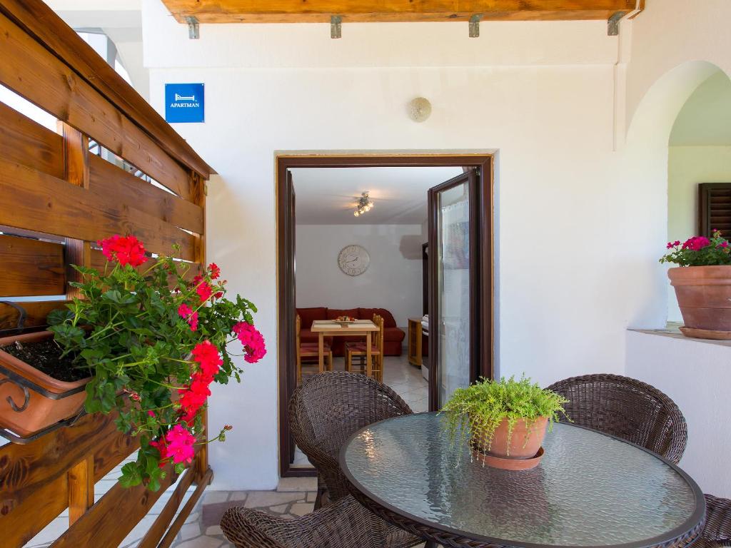 a patio with a table and chairs and flowers at Apartments Špadići in Poreč