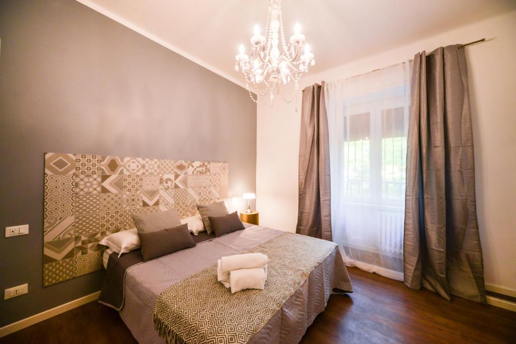 a bedroom with a bed and a chandelier at Casa Ferrovieri in Verona
