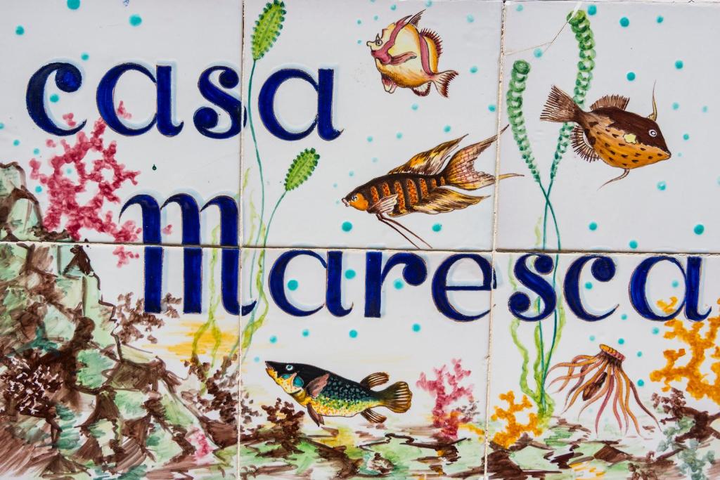 a sign for a school of fish with the words casa illiterranean at Casa Maresca Residence in Positano