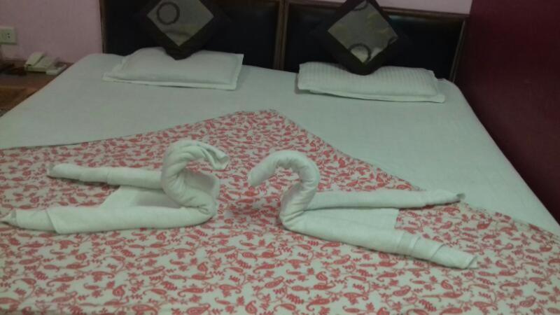 Dos cisnes hechos de toallas en una cama en Hotal Balaji en Gwalior
