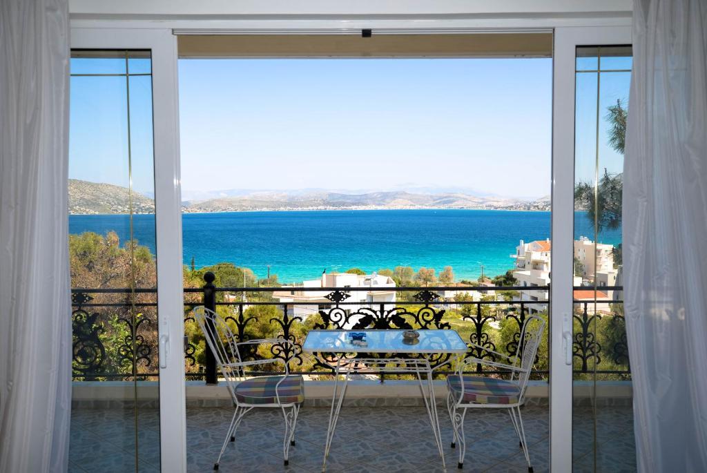 una mesa y sillas en un balcón con vistas al océano en Aias Summer House, en Aiándion