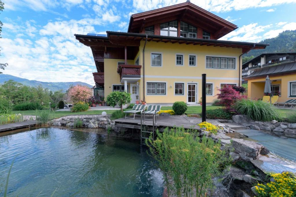 a house with a pond in front of it at Haus am Hammerrain in Flachau