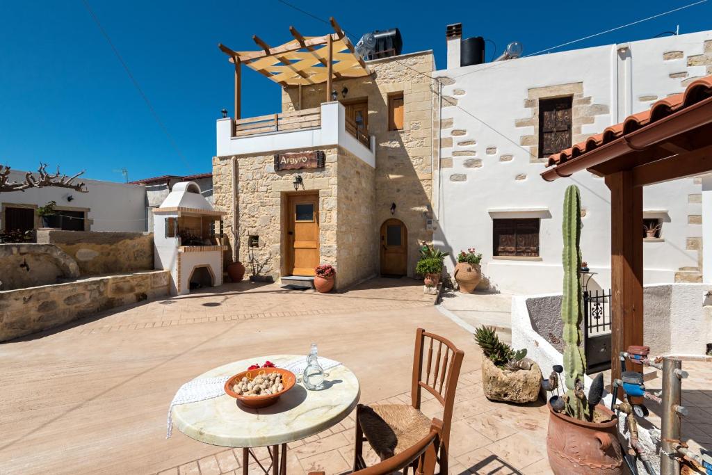 a patio with a table and chairs and a building at Villa Argyro in Azoyirás