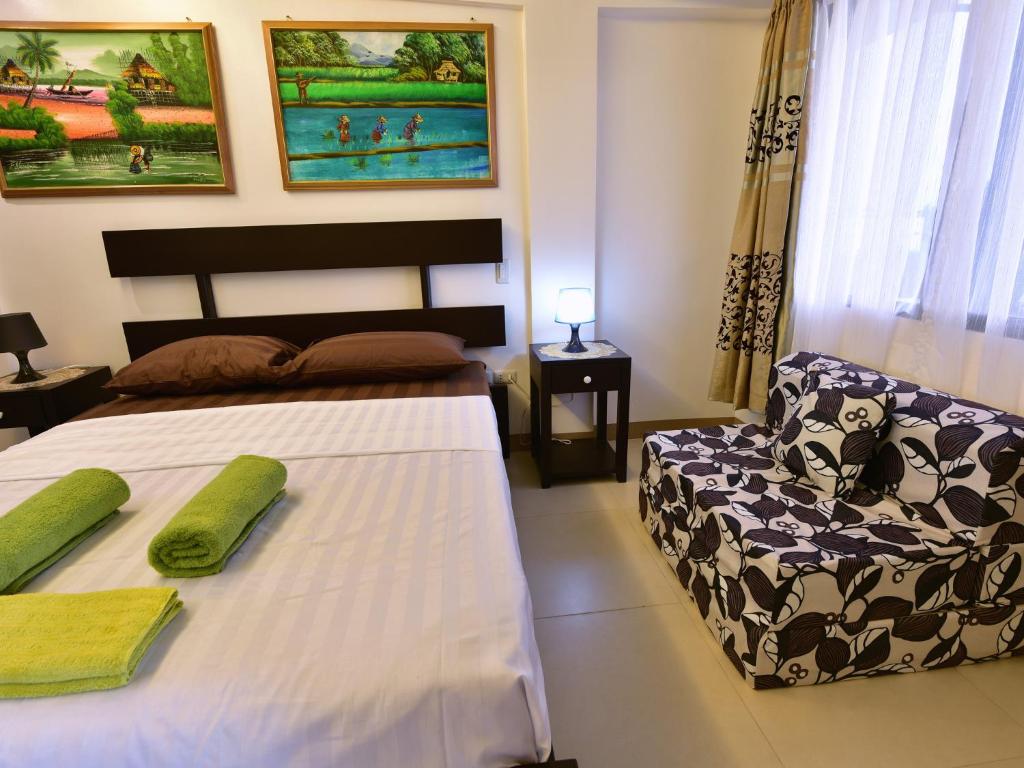 1 dormitorio con 1 cama y 1 silla en Anahaw Apartments Whitebeach en Boracay