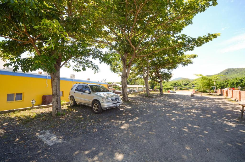 a car parked in a parking lot next to trees at Ciao House B&B in Kenting