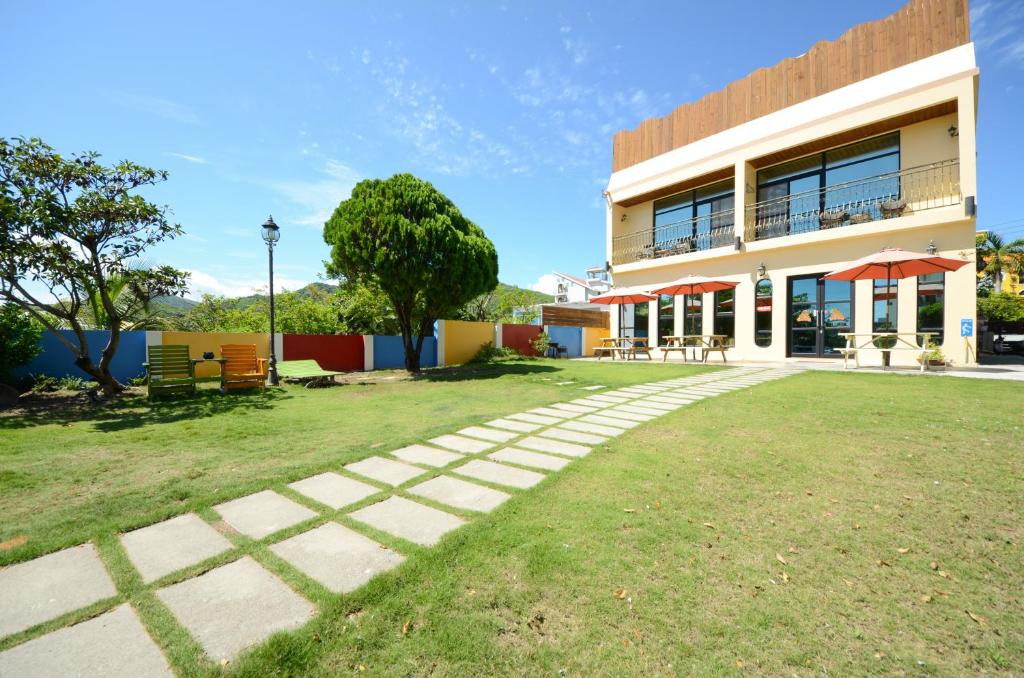 un edificio con un patio de césped delante de él en Ciao House B&B, en Kenting